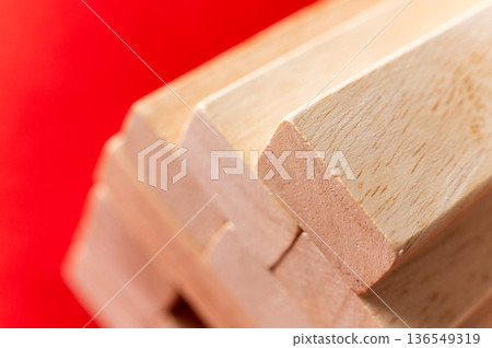 Stacked wooden blocks with smooth edges and natural wood grain on a vibrant red background, showcasing texture and craftsmanship in a close-up view 136549319