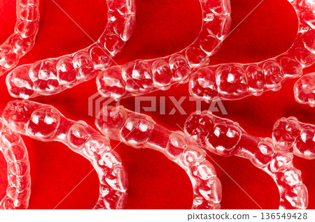 Extreme macro close-up of clear braces. Multiple aligners against a colored background, close-up with a shallow depth of field. 136549428