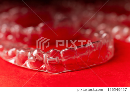 Clear aligners and braces on a colored background. Many clear hedgehog braces on a colored background. Dental background. Technological dentistry. 136549437