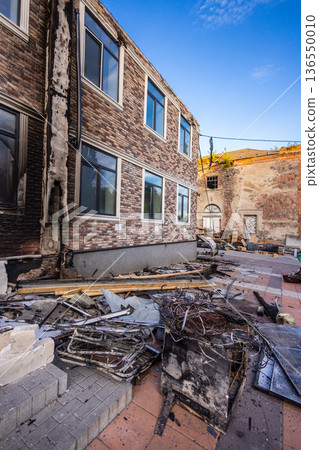 Bila Tserkva, Kyiv region, Ukraine - 09.06.2025: Burned building exterior with charred walls, broken windows, and scattered debris showing severe fire damage in an urban setting. Bila Tserkva, Kyiv region, Ukraine - 09.06.2025: Burned building exterior with charred walls, broken windows, and scattered debris showing severe fire damage in an urban setting. 136550010