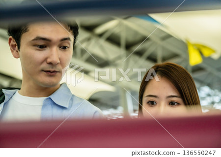 Men and women checking the screen at the airport ■Photography cooperation: Kansai International Airport (KIX) 136550247