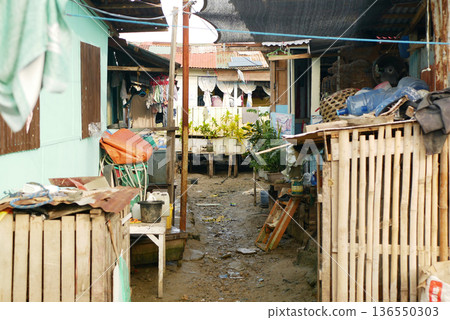 People poor urban poverty homeless slum poor port community Philippines improvising house coastal port areas in Mactan Cebu high population ghetto squatter neighborhood wooden corrugated metal sheet 136550303