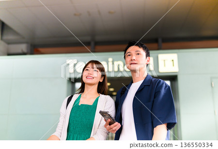 A couple looking up at the airport. Photo courtesy of Kansai International Airport (KIX). 136550334