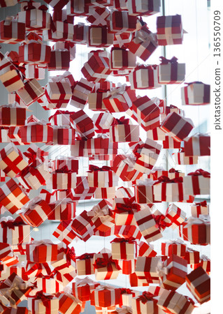 Decorative background of floating gift boxes with red ribbons 136550709