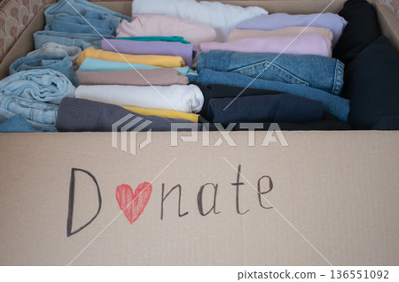 Box filled with neatly folded clothes ready for donation at a local charity for those in need 136551092