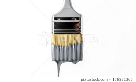 a paintbrush is partially dipped in gray paint, with drips of paint hanging from the bristles 136551363