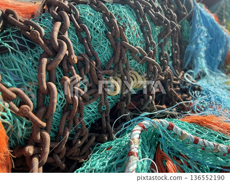 Multicolored orange blue fishing nets chain in the port Multicolored orange blue fishing nets chain in the port 136552190