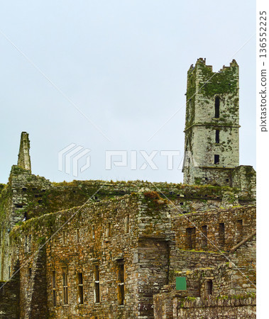 Timoleague Friary. Ancient stone monastery ruins against a bright sky. Historical Irish abbey in a state of disrepair. Timoleague Friary. Ancient stone monastery ruins against a bright sky. Historical Irish abbey in a state of disrepair. 136552225