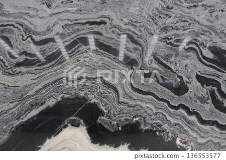Black and white granite marble with dynamic wave patterns resembling water flow for a strong visual look. 136553577