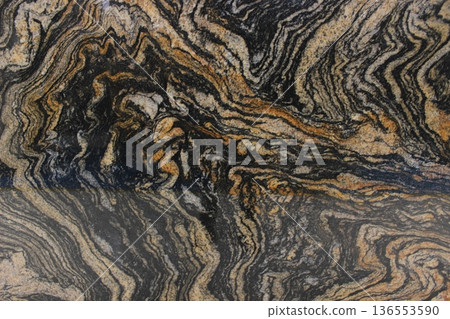 Magma Gold granite texture from Brazil with dramatic black and gold wave patterns, suitable for luxury interior design. Magma Gold granite texture from Brazil with dramatic black and gold wave patterns, suitable for luxury interior design. 136553590