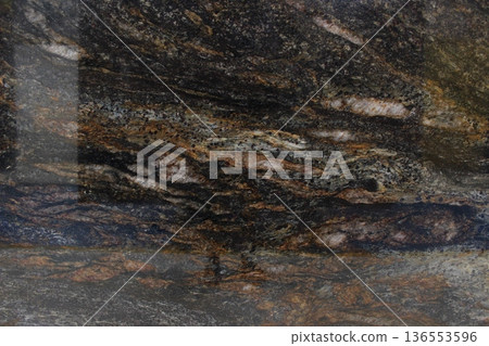Close-up of a Titanium granite slab showing unique mineral composition with a blend of dark colors and shimmering copper accents. Close-up of a Titanium granite slab showing unique mineral composition with a blend of dark colors and shimmering copper accents. 136553596