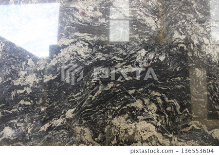 Black Marinace marble texture with dense grey and black circular vein patterns, unique natural stone for contemporary interior accents. Black Marinace marble texture with dense grey and black circular vein patterns, unique natural stone for contemporary interior accents. 136553604