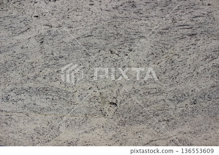 Detail of white granite texture with evenly distributed small grey mineral grains, durable natural stone for exterior floors and walls. Detail of white granite texture with evenly distributed small grey mineral grains, durable natural stone for exterior floors and walls. 136553609