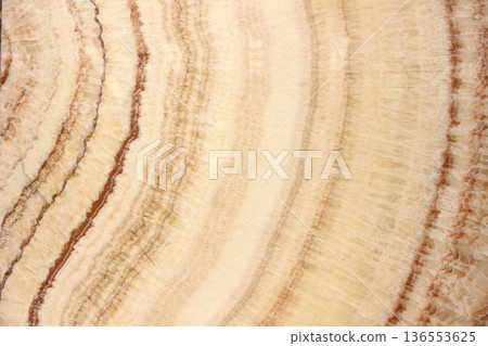 Honey Onyx marble texture with concentric circular patterns and warm orange and beige color gradations. 136553625