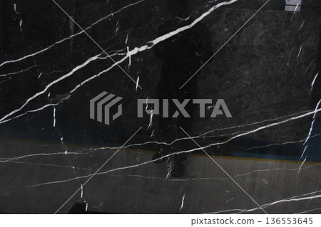 Black Nero Marquina marble with light reflections on the polished surface showing bold white veins. Black Nero Marquina marble with light reflections on the polished surface showing bold white veins. 136553645