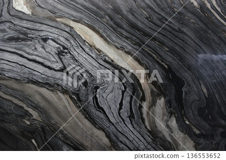 Black Forest marble texture with intense black and dark grey vein flow patterns resembling natural wood grain. Black Forest marble texture with intense black and dark grey vein flow patterns resembling natural wood grain. 136553652