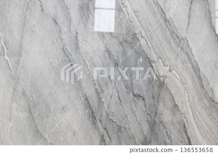 Volakas marble texture from Greece with a white base and soft grey diagonal veins resembling water flow. 136553658