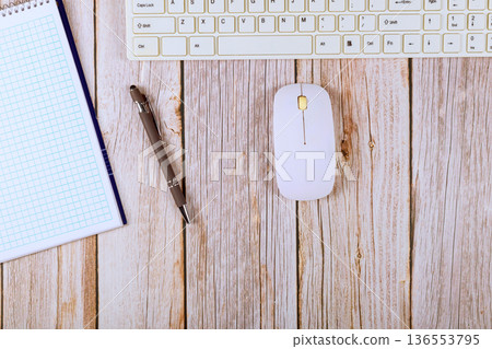 Workspace setup with keyboard, mouse, notebook, pen on office table 136553795
