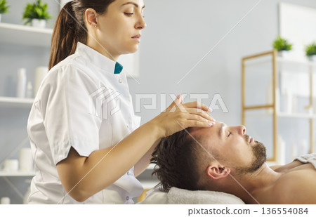 Man relaxing during spa facial massage, close-up 136554084