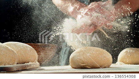 Chef Clapping Flour-Covered Hands. Flour Explosion During Yeast Dough Preparation, Baking Concept on Dark Background 136554308