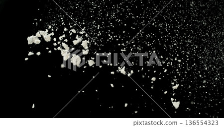 Falling white powder, flour particles floating and dispersing in air, isolated on black background. Detailed texture and dynamic dust cloud effect. Falling white powder, flour particles floating and dispersing in air, isolated on black background. Detailed texture and dynamic dust cloud effect. 136554323