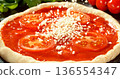 Closeup of grated mozzarella falling onto fresh pizza with tomato sauce and sliced tomatoes. Detailed texture, flying cheese particles and dynamic motion. Concept of pizza preparation and cooking. 136554347