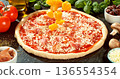 Closeup of fresh pineapple pieces falling onto prepared Hawaiian pizza. Raw dough with tomato sauce, mozzarella and ham surrounded by ingredients. Concept of pizza preparation. 136554354