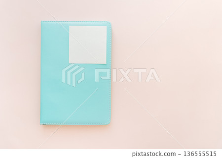 Turquoise notebook with blank sticky note on pastel background, minimal flat lay Turquoise notebook with blank sticky note on pastel background, minimal flat lay 136555515