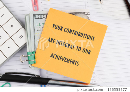 Yellow sticky note: YOUR CONTRIBUTIONS ARE INTEGRAL TO OUR ACHIEVEMENTS atop cash, next to a calculator pen on a desk Yellow sticky note: YOUR CONTRIBUTIONS ARE INTEGRAL TO OUR ACHIEVEMENTS atop cash, next to a calculator pen on a desk 136555577