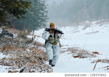 Soldier In Winter Camouflage Patrolling Snowy Forest With Rifle During Military Training Exercise 136555642