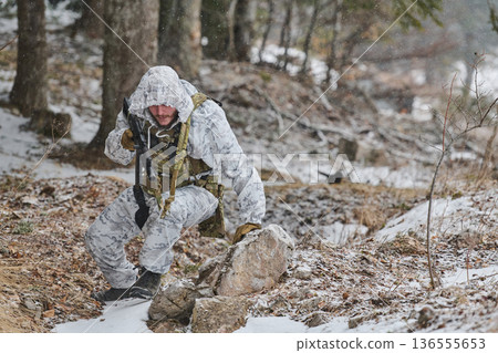 Soldier In White Winter Camouflage Patrolling Snowy Forest With Rifle During Cold Weather Operation Soldier In White Winter Camouflage Patrolling Snowy Forest With Rifle During Cold Weather Operation 136555653