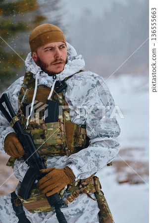 Soldier In Winter Camouflage Holding Rifle During Snowy Patrol With Tactical Vest And Gloves 136555663
