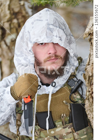 Winter Soldier In Snow Camouflage With Tactical Knife And Plate Carrier In Forest 136555672