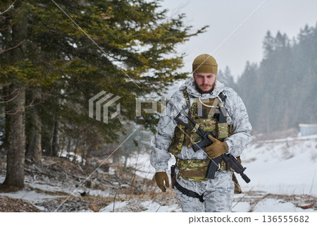 Soldier In Winter Camouflage Patrol With Rifle Walking Through Snowy Forest During Light Snowfall Soldier In Winter Camouflage Patrol With Rifle Walking Through Snowy Forest During Light Snowfall 136555682