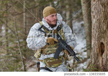 Armed Soldier In Winter Camouflage Patrol Carrying Rifle Through Snowy Forest During Training Operation 136555695