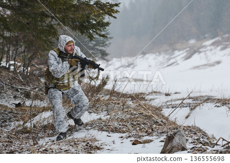 Soldier In Winter Camouflage Patrols Snowy Forest With Rifle During Cold Weather Training Exercise Soldier In Winter Camouflage Patrols Snowy Forest With Rifle During Cold Weather Training Exercise 136555698