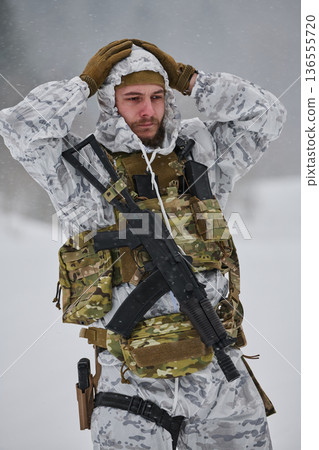 Soldier In Winter Camouflage Gear Holding Rifle In Snowy Training Exercise With Concerned Expression Soldier In Winter Camouflage Gear Holding Rifle In Snowy Training Exercise With Concerned Expression 136555720