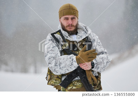 Armed Soldier In Winter Camouflage Gear Standing In Snowy Landscape During Snowfall 136555800