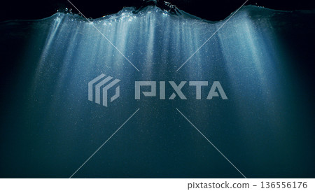 Dark Blue Ocean Surface Seen from Underwater. Abstract Waves and Rays of Sunlight Shining Through 136556176