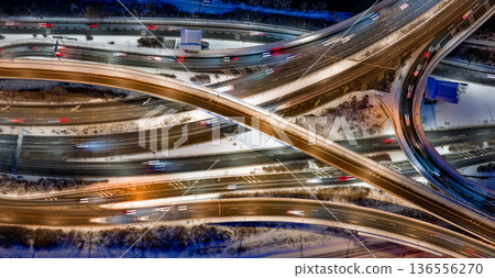 Top-down view of moving cars on a city crossroad during evening rush hour 136556270