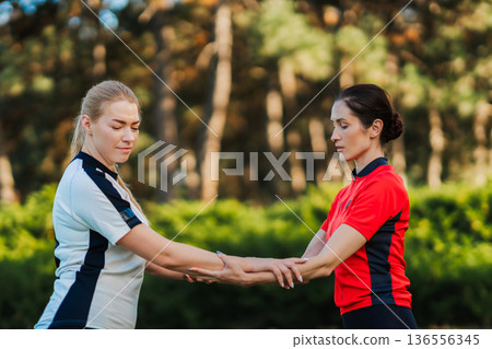 Women practicing martial arts in outdoor setting Women practicing martial arts in outdoor setting 136556345