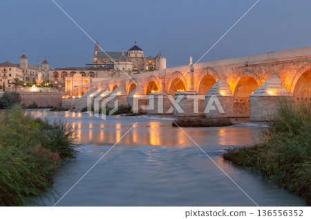 Illuminated Roman Bridge and Mezquita Cathedral at Night in Cordoba Spain 136556352