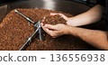 Close-up and high-detail shot of male hands carefully holding coffee beans  136556938