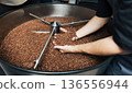 Close-up and high-detail shot of male hands carefully holding coffee beans  136556944