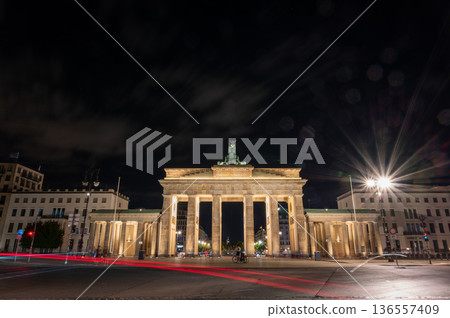 Berlin, germany, august 14, 2023. Brandenburg gate in berlin standing illuminated at night, featuring historic architecture with long exposure car light trails Berlin, germany, august 14, 2023. Brandenburg gate in berlin standing illuminated at night, featuring historic architecture with long exposure car light trails 136557409