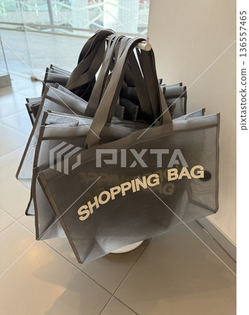 Shopping bags displayed in a retail store setting, ideal for modern consumerism themes 136557465