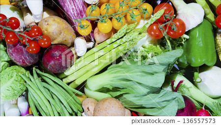Fresh vegetables and fruits gathered together on a table for cooking or meal preparation in a kitchen setting Fresh vegetables and fruits gathered together on a table for cooking or meal preparation in a kitchen setting 136557573
