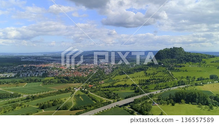 Scenic view of a city and mountains under a cloudy sky during daylight hours Scenic view of a city and mountains under a cloudy sky during daylight hours 136557589