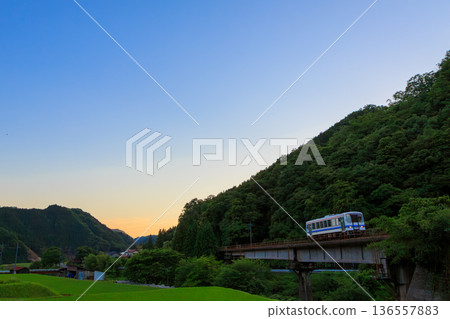 暮色漸濃，一列三光柴油列車穿梭於山間。 136557883