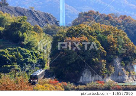 The Kure Line runs along the foot of the Akinada Bridge, where the autumn leaves are still visible. 136557890